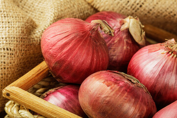 Basket of Red Onions on  burlap background with copy space