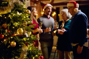 Close up of Christmas tree with family in background.