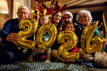 Close up of extended family with 2024 balloons during New Year celebration.