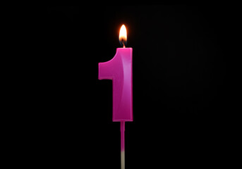 Burning pink birthday candle isolated on black background. Number 1.