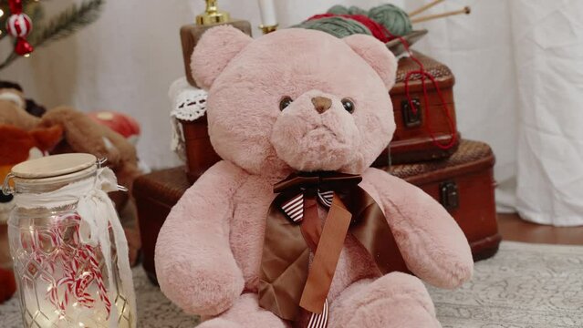 Plush teddy bear with striped bow tie amidst vintage Christmas decor