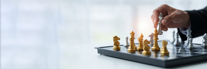 Businessman's hands move chess figures and checkmate opponent during match. Strategy, management, leadership, analysis of development for organizational success. copy space, banner, panorama