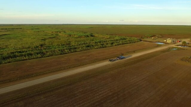 Aerial Shot Of Pickup Truck Towing Boat On Road, Drone Flying Forward Over Agricultural Landscape - Bayou, Louisiana