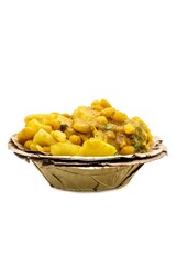 Alu Chat or Aloo Ghugni Garnished with Onion Cuts, Black Salt, Coriander in a Dried Leaves Disposable Bowl Isolated on White Background, Spicy Potato Pea Curry, Indian Street Food