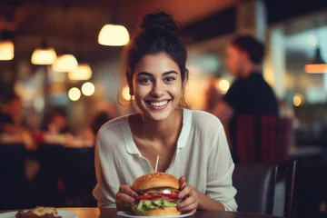 Deurstickers Indian college girl eating burger © PRASANNAPIX