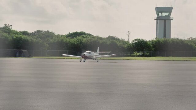 Pan shot of a parked light aircraft at an airport's runway
