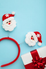 Christmas headband Santa Claus head design with white gift with red bow on blue background.