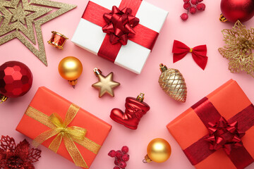 Christmas composition. Gifts, red and gold decorations on pink background. New year concept.