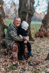 little boy in the autumn forest with his grandparents