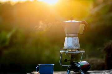 Moka pot and smoke, Steam from the coffee pot on fire, In the forest at sunrise in the morning....