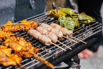 Grilling various meats on short, thin bamboo skewers over an open fire or grill