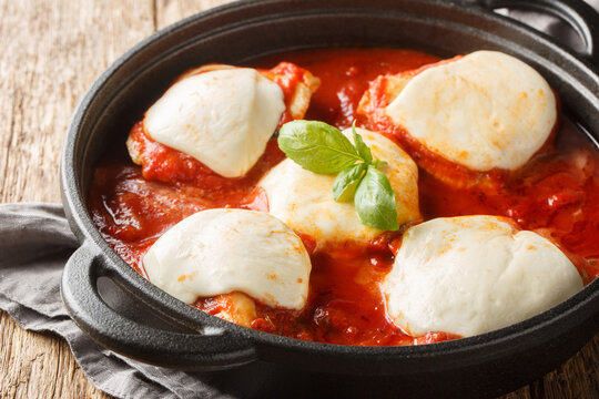 Italian chicken pizzaiola traditional recipe with basil and mozzarella close-up on the pan on the table. horizontal