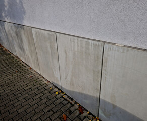 cladding of the house consists of concrete slabs with gaps with a ventilation grid protecting the...