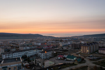 Morning cityscape. Aerial view of the city at dawn. Top view of buildings. In the distance is a sea bay. Early morning. City of Magadan, Magadan region, Siberia, Far East of Russia.
