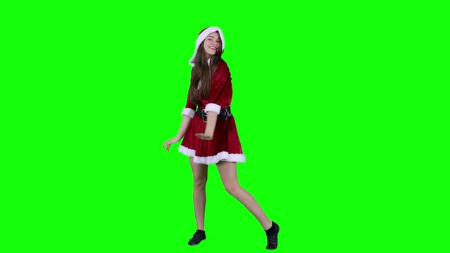 Happy woman 20s in red dress Santa Christmas dancing fooling around having fun expressive gesticulating hands isolated on green screen background studio. Happy New Year merry holiday concept