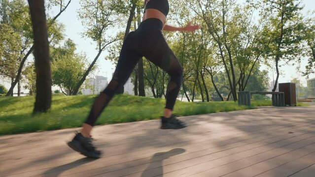 athlete running fast outdoors energy and power concept. training in the city with urban view. fit young woman jogging at sunrise