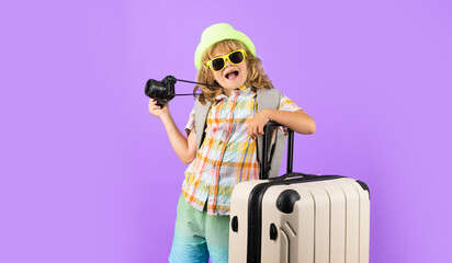 Child tourist with travel bag travelling. Kid with suitcase on studio isolated background.