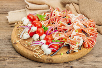 Set of picnic snacks on skewers. Jamon, mozzarella, cherry tomatoes, peas, fresh greens