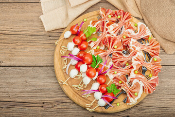 Set of picnic snacks on skewers. Jamon, mozzarella, cherry tomatoes, peas, fresh greens