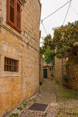 Fototapeta na wymiar A street in Supetar on Brac Island, Croatia, with traditional kogule or kogulavanje paving. Common in coastal villages throughout Dalmatia, it uses pebbles from beaches