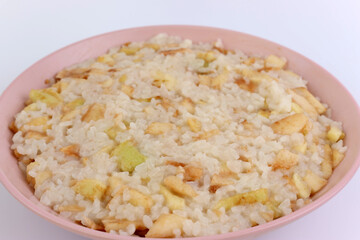 Rice porridge with apples in a bowl close-up.