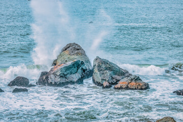 Water splashes close up. Crystal clear sea water beats against the rocks. Sea waves break on the...