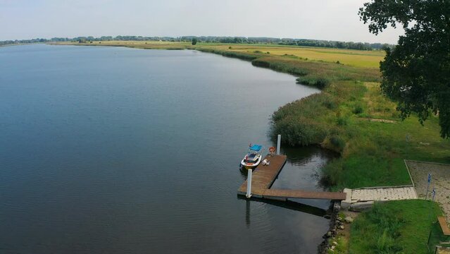 aerial view of small pier near the river with fields in the background