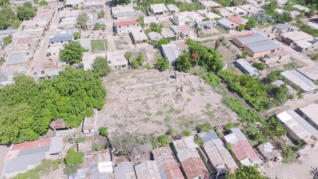 Aerial top down shot of poor neighborhood and tomb in PUEBLO VIEJO AZUA, Dominican Republic  - Tilt up shot 