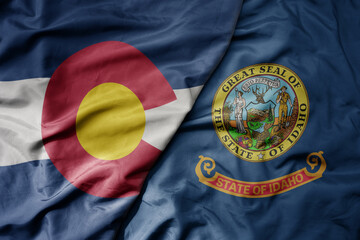 big waving colorful national flag of idaho state and flag of colorado state .