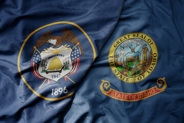 big waving colorful national flag of idaho state and flag of utah state .