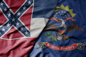 big waving colorful national flag of north dakota state and flag of mississippi state .