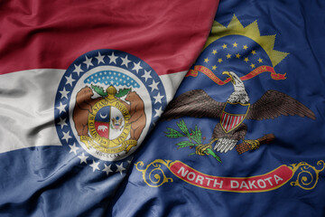 big waving colorful national flag of north dakota state and flag of missouri state .