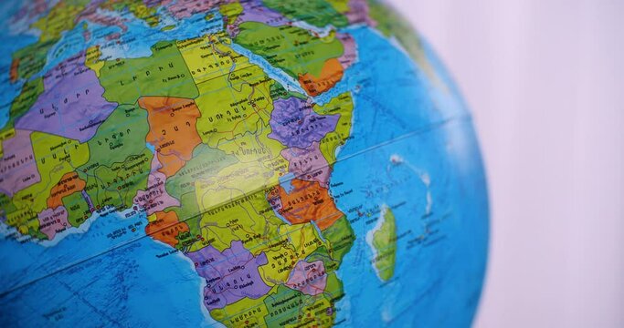 Close-up of globe with map of Africa and oceans on gray background. On the globe there are Armenian letters.