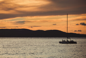 Boat at sunset. Small yacht drifting in the Adriatic sea in Croatia at dusk