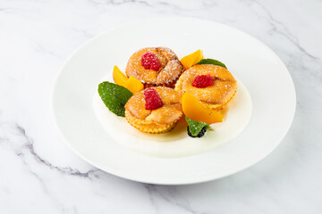 muffins with peach, raspberry, black berry and mint covered with powdered sugar, side view