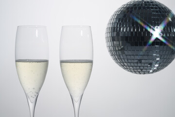Two glasses of champagne with disco ball