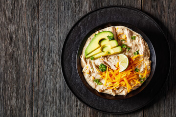 white chicken chili with cheese, avocado in bowl