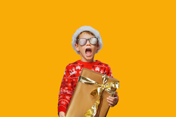 Christmas boy with the gift against a isolated background. Cry of happiness. Christmas joy concept.