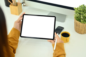 Above view of creative woman holding stylus pen and using digital tablet at office desk