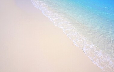 Weißer Sandstarnd mit Wellen und blauem Meer