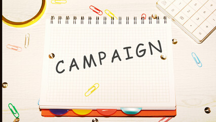 Campaign word on a checkered notebook on a light table next to a magnifying glass, paper clips,...
