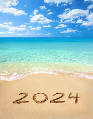2024 written on sandy beach - 676295943