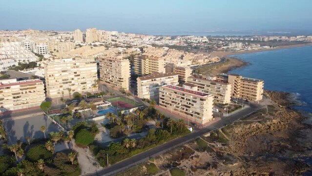 Drone aerial Panorama Pan of Cabo Cervera and La Mata beach, Torrevieja during a beautiful golden hour morning showing playground at a the park