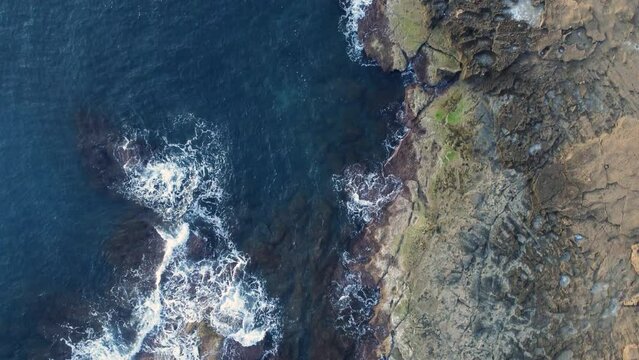 Aerial top down shot of waves hitting cliffs at Cabo Cervera, Torrevieja