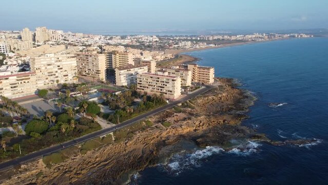 Aerial drone view of cabo cervera and La Mata beach, Torrevieja during a beautiful golden hour morning. Waves crashing on the shore and the sea showing