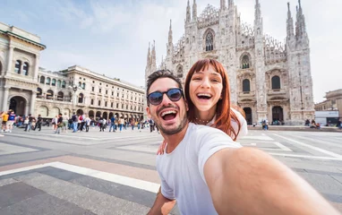 Deurstickers Happy couple taking selfie in front of Duomo cathedral in Milan, Lombardia - Two tourists having fun on romantic summer vacation in Italy - Holidays and traveling lifestyle concept © Davide Angelini