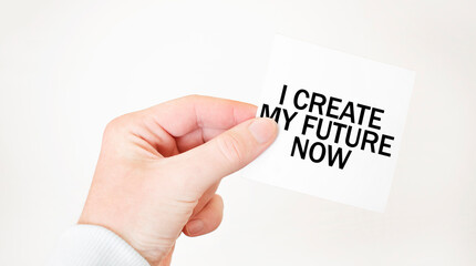 Businessman holding a card with text I CREATE MY FUTURE NOW, business concept