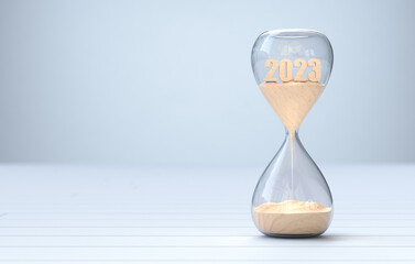 New Year 2024, The time of 2023 is running out in the hourglass - obrazy, fototapety, plakaty