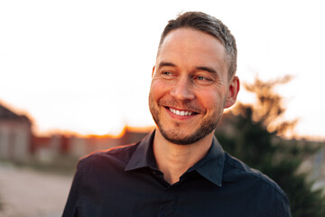 Portrait of handsome successful man standing outdoors