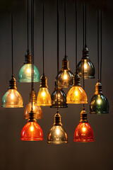 A bunch of isolated Vintage multi color light bulbs hanging from a ceiling.